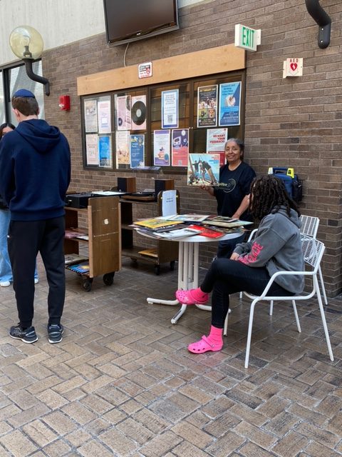 Librarian Gisele holds up a vinyl record in Galleria