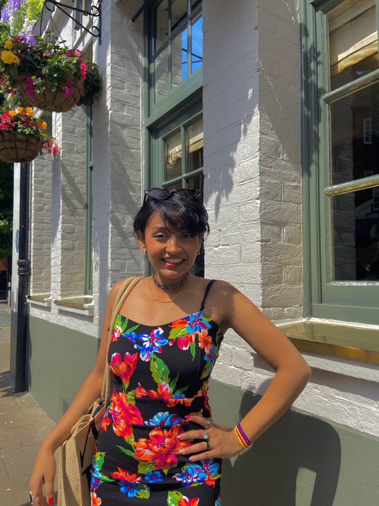 SBU English and Studio Art major Ellaha  stands outside in a floral dress.