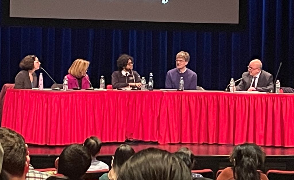 Five panelists sitting at a table.