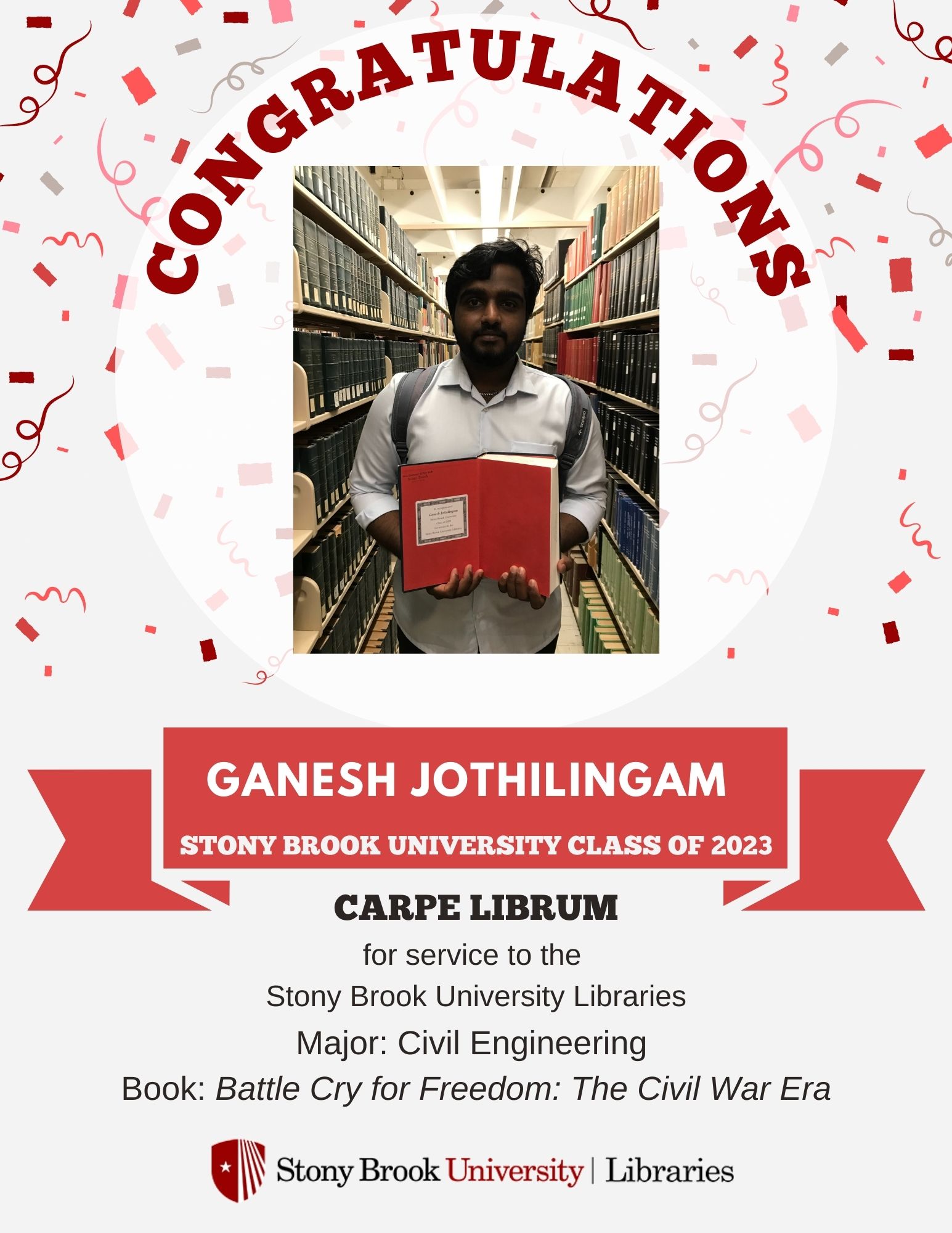 Student holding a book in front of library stacks