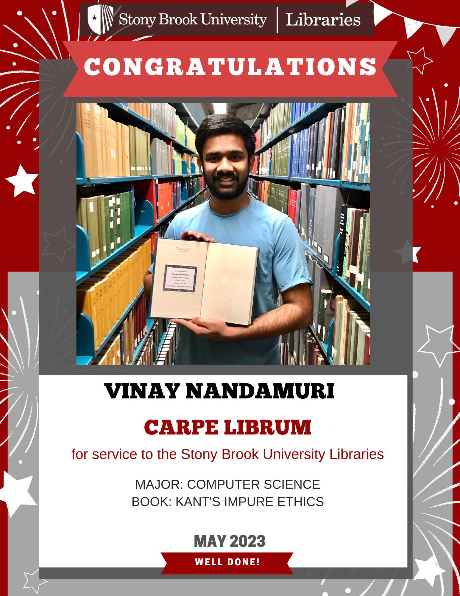 Student holding a book in front of library stacks