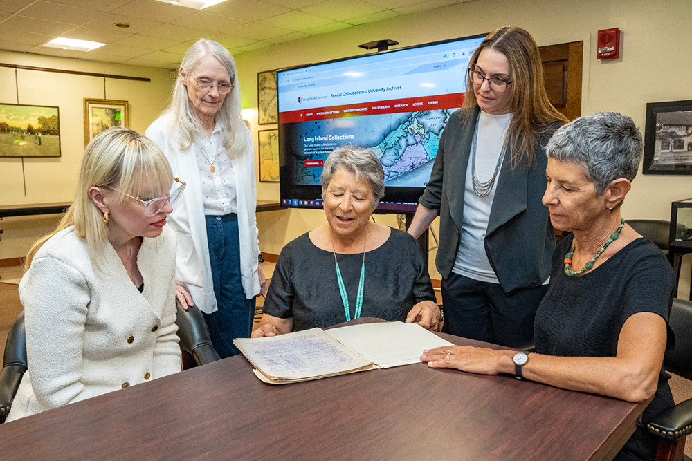 Cathy Barbash (center) and Susan Barbash (far right) present to (left to right) Stony Brook University Special Collections members Kristen Nyitray, Lynn Toscano and Jamie Saragossi a collection of papers relating to the creation of the Fire Island National Seashore. Photo by John Griffin.