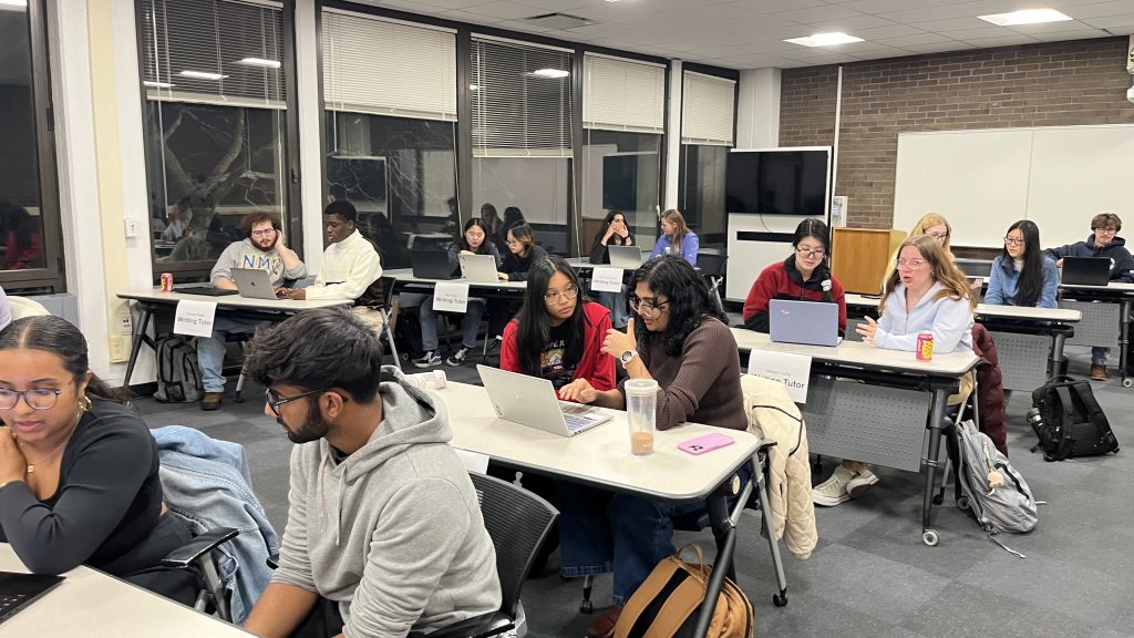 Several tables of students sitting and talking together.