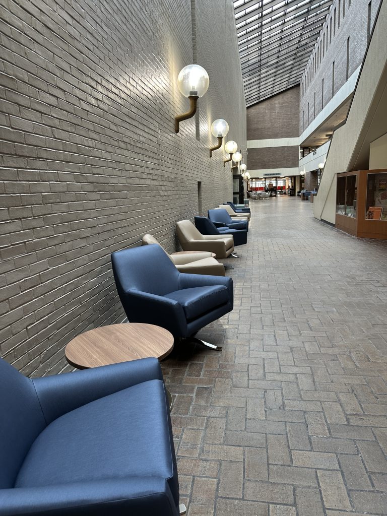 Row of blue and beige seats along a wall.