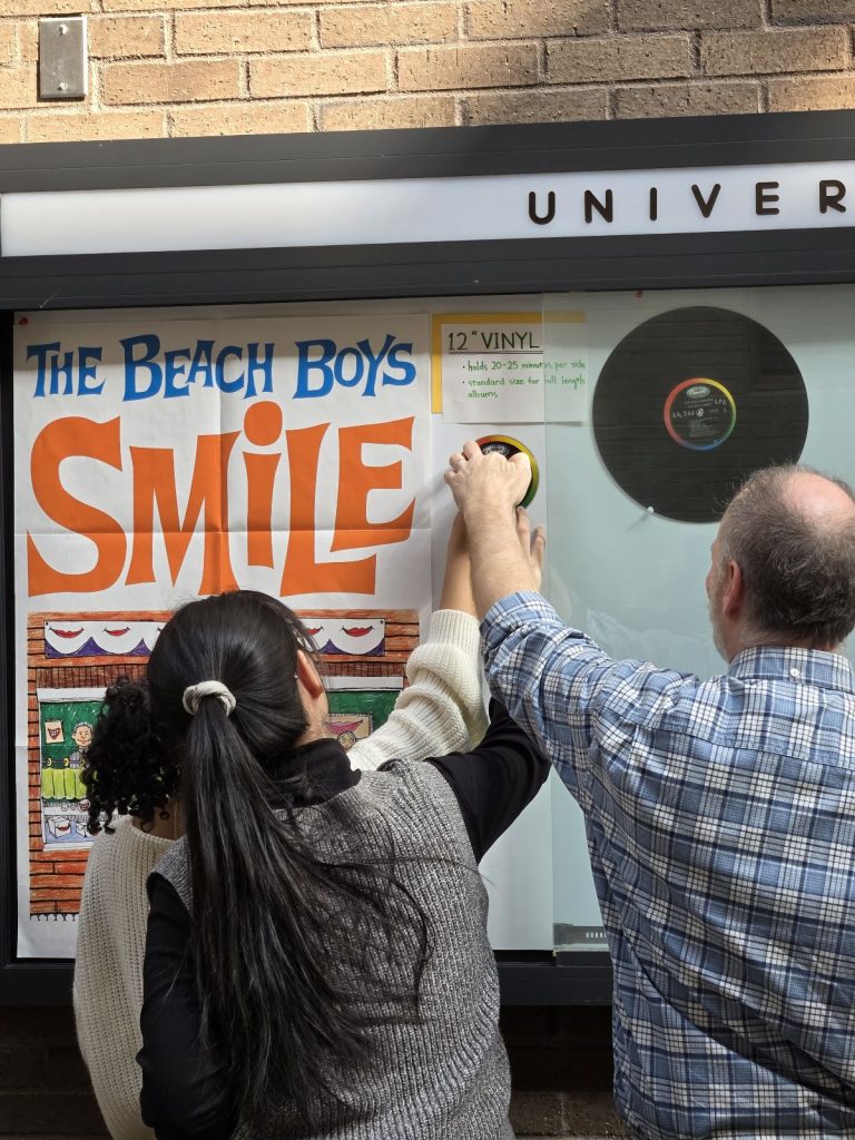 Three people installing a display.