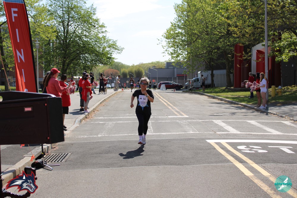 Woman running across finish line.
