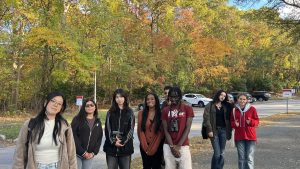 A group of students posing in front of the trees