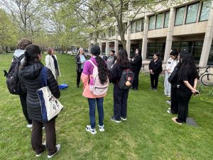 Students and faculty gathered on the grass in front of the Melville Library