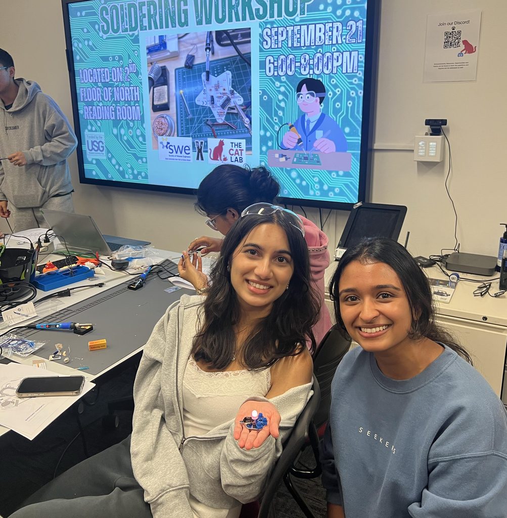 two students showing their successful soldering